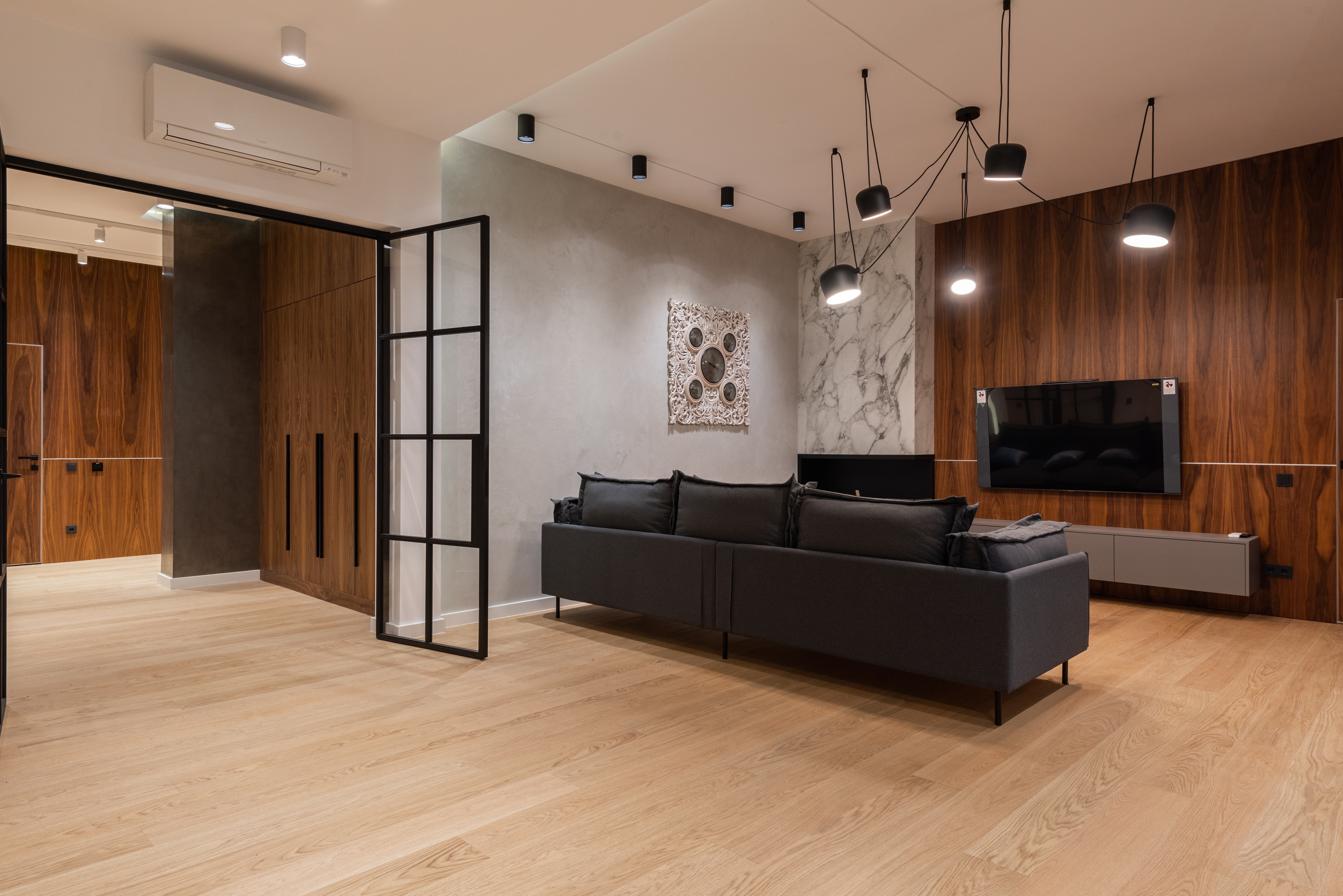 Fernsehzimmer mit dunkelbrauner Holzwand und hellbraunen Vinylboden in Holzdekor