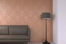 Kreative Wandbeschichtung in Lachsfarbe an einer Wohnzimmerwand hinter einem Sofa