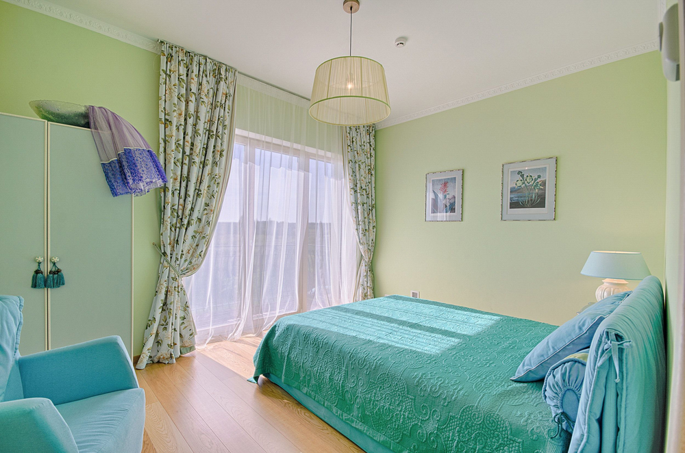 Grün gestrichene Wände in einem Schlafzimmer schaffen vertraute Atmosphäre