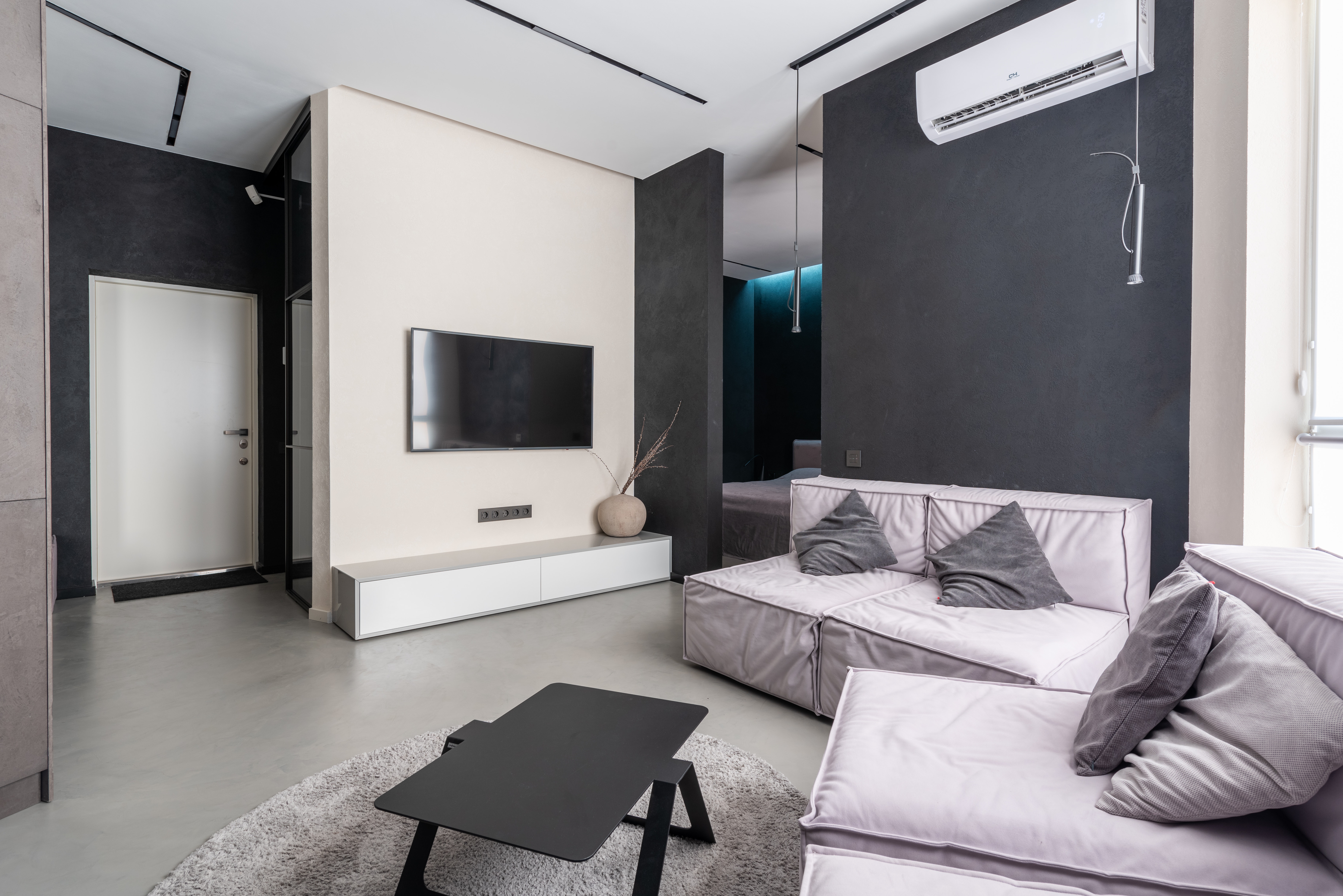 Modern eingerichtetes Wohnzimmer mit hellgrauem fugenlosem Boden 