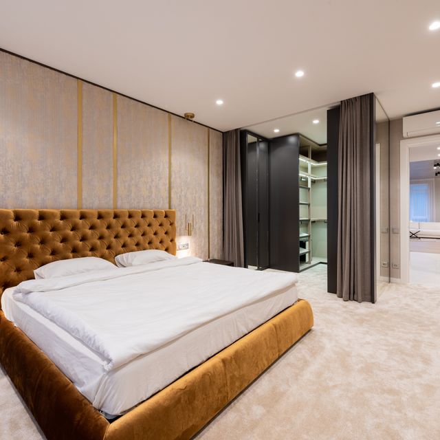 Schlafzimmer mit Vliestapete und samtigem Teppichboden in hellbeige
