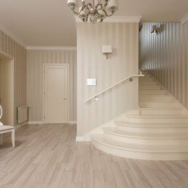 Treppenaufgang mit gestreifter Tapete in Beigetönen und passendem Vinylboden