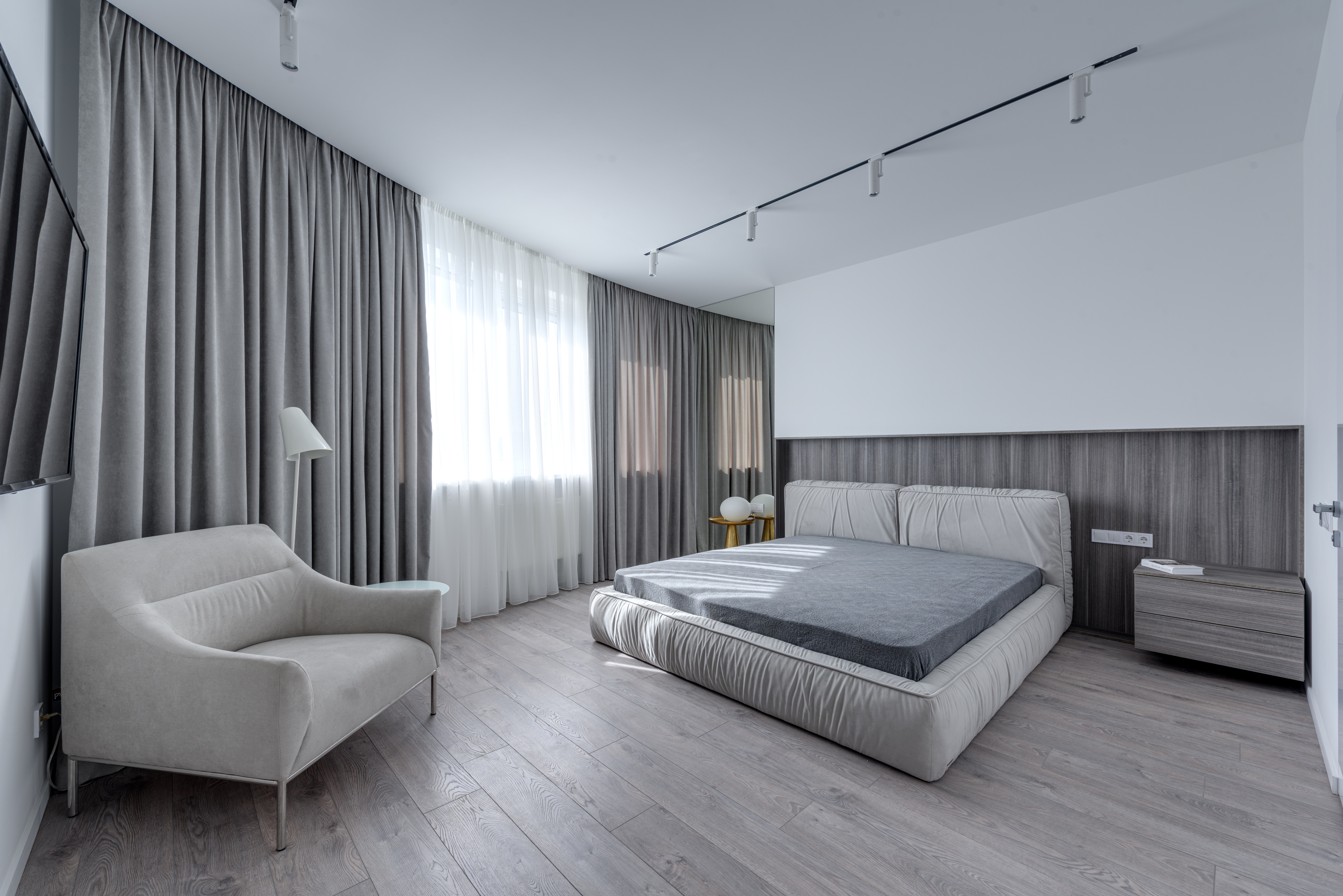 Schlafzimmer mit grauen Möbeln und hellgrauem Designboden in Holzoptik