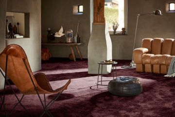Wohnzimmer mit dunkelroten Teppich und Hellbrauner Ledercouch