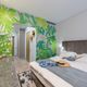 Blätter auf einer Mustertapete verwandeln ein Schlafzimmer in einen Dschungel